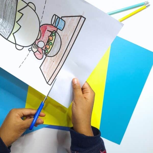 A child carefully cutting out a Ramadan topper, preparing it for their craft activity.